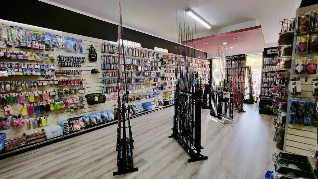 Reparto canne da pesca del negozio Centro Pesca Brando a Palmi con parete di esche artificiali in blister e prodotti Savage Gear